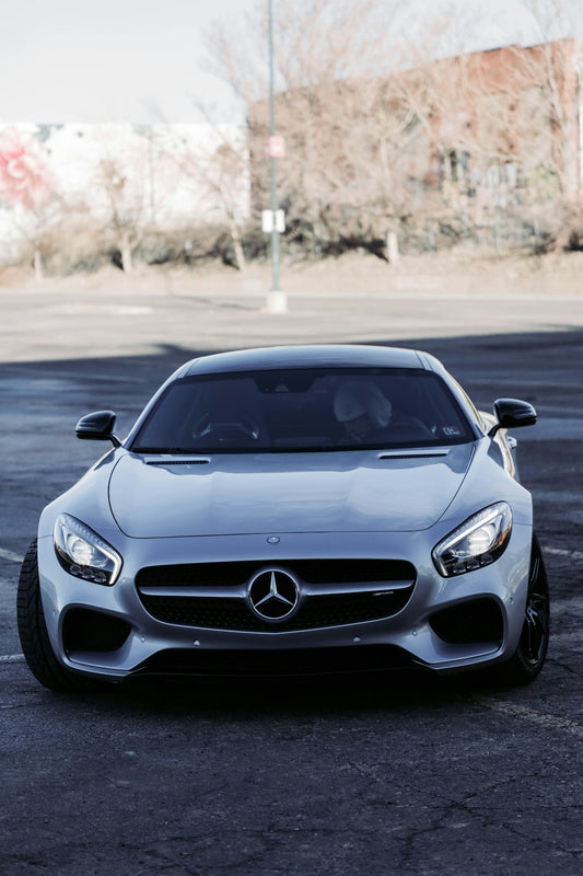 a silver mercedes sports car parked in a parking lot
