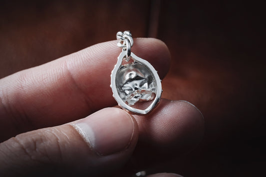 a person holding a silver ring in their hand
