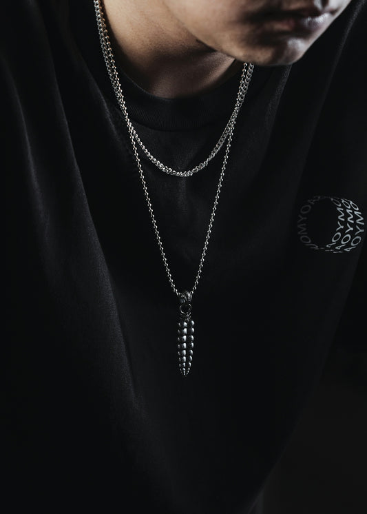 a man wearing a black shirt and a silver necklace