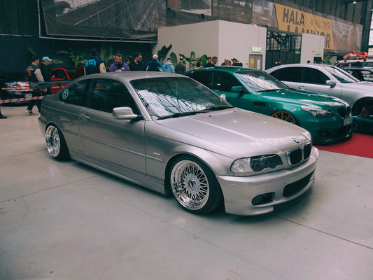a silver car parked in a garage next to other cars