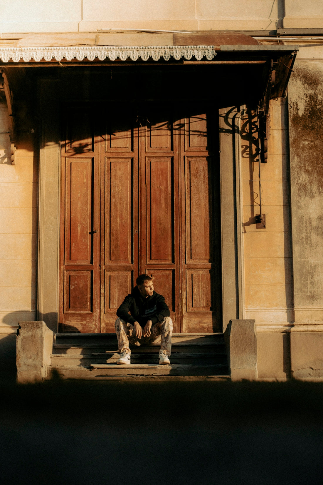 a man sitting on a step in front of a building