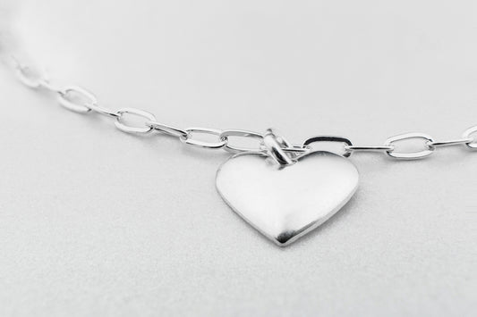 a silver heart charm on a silver chain