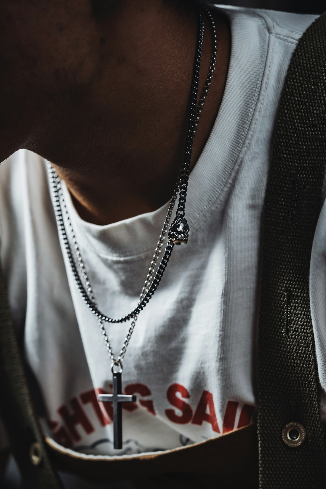 a man wearing a white shirt and a cross necklace